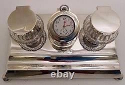 A solid silver two-bottle inkstand with a centre clock, by John Grinsell 1904