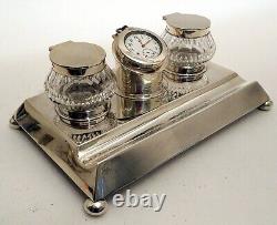A solid silver two-bottle inkstand with a centre clock, by John Grinsell 1904